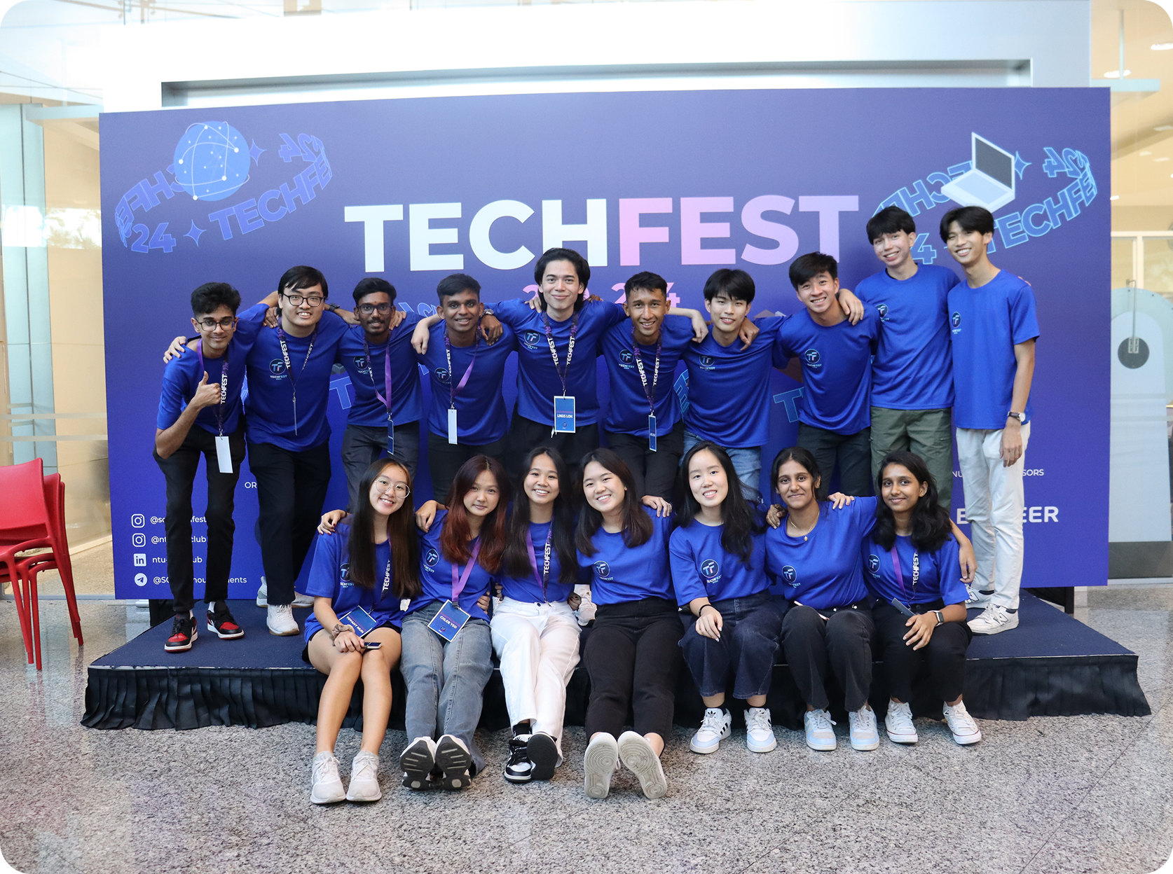 Group of students at TechFest event with blue backdrop